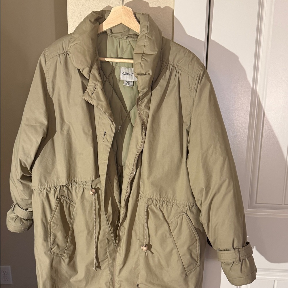 Stylish brown parka with quilted lining, adjustable waist, deep pockets, and zip